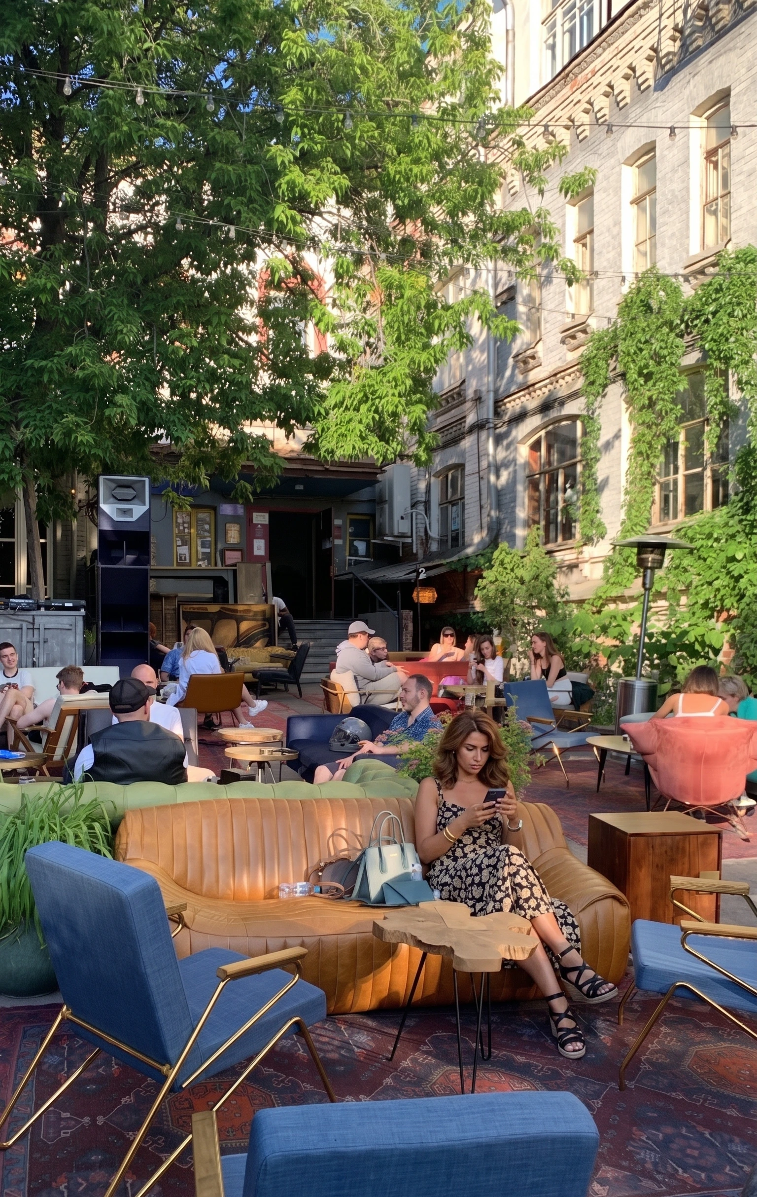 Outdoor cafe at golden hour with people gathered at shared tables